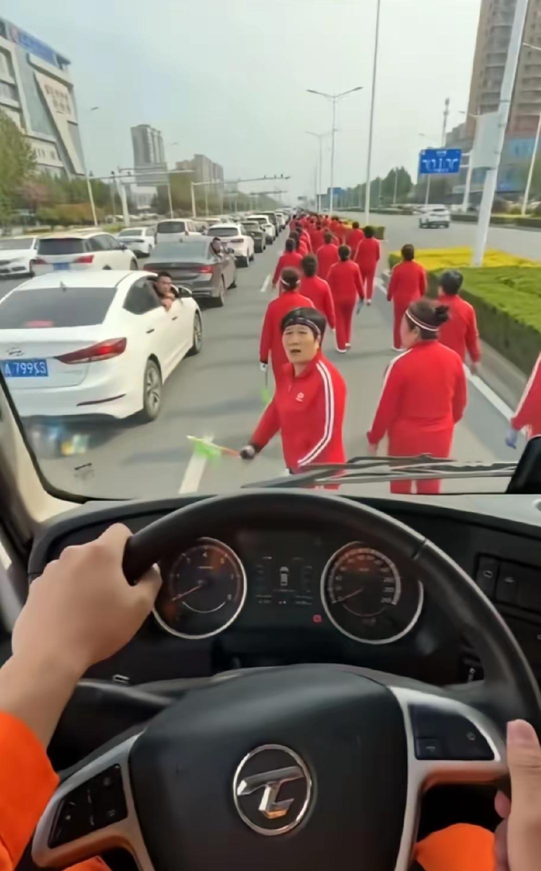 早高峰，洒水车正常出工，被暴走团堵了个严严实实。司机按喇叭，一位大妈回头就吼：