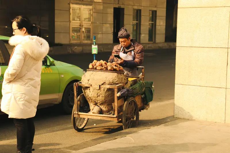 南京这起案子真够奇葩的。2023年2月，75岁卖红薯老人遇到戴口罩头盔女子用假币