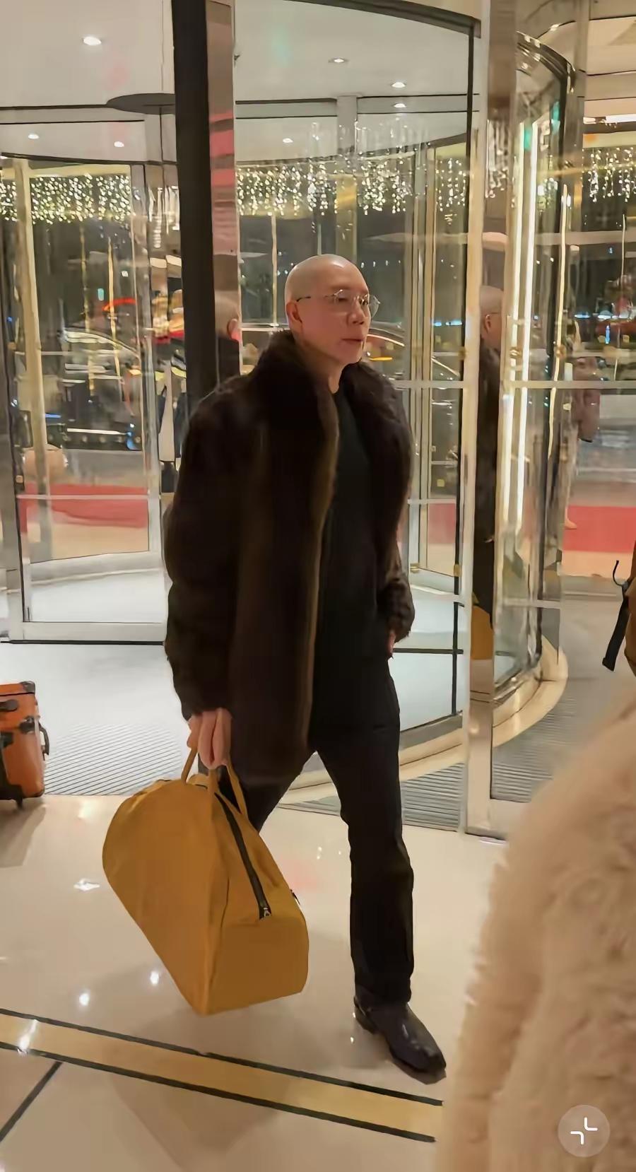 王菲的造型师在王菲春晚演出结束后立场，做为造型师的他，衣品也是一言难尽，身穿皮草