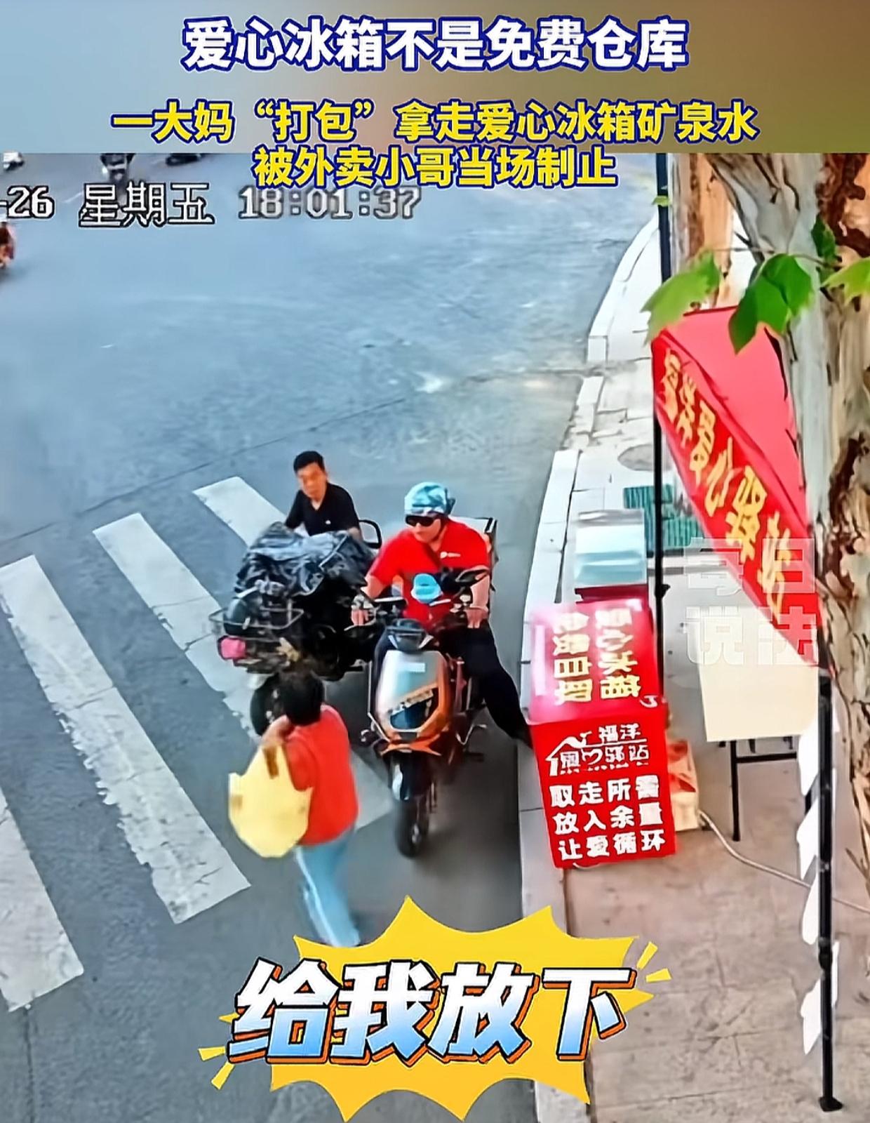 6月26日，山东临沂一位大妈从爱心冰箱取了10几瓶水，背起就走。一位外卖小哥正好