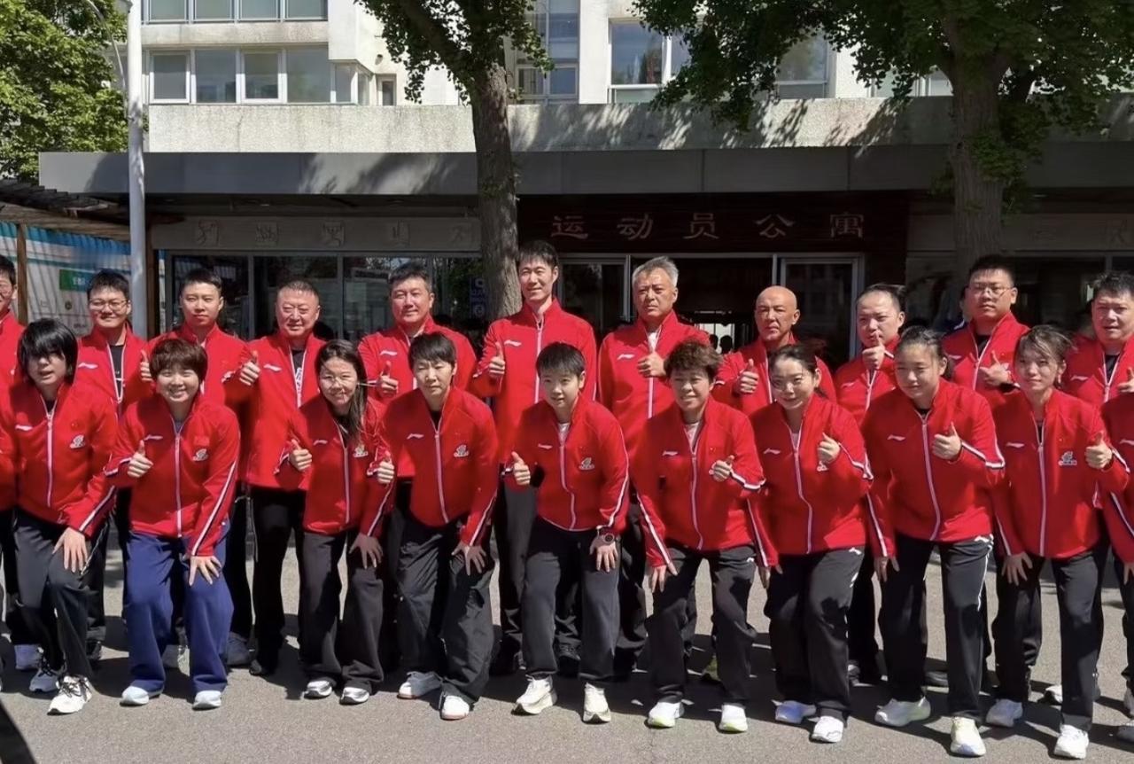 国乒出征大合照出来了孙颖莎和王曼昱站中间，背后是教练组，新队服的大红色，也是为