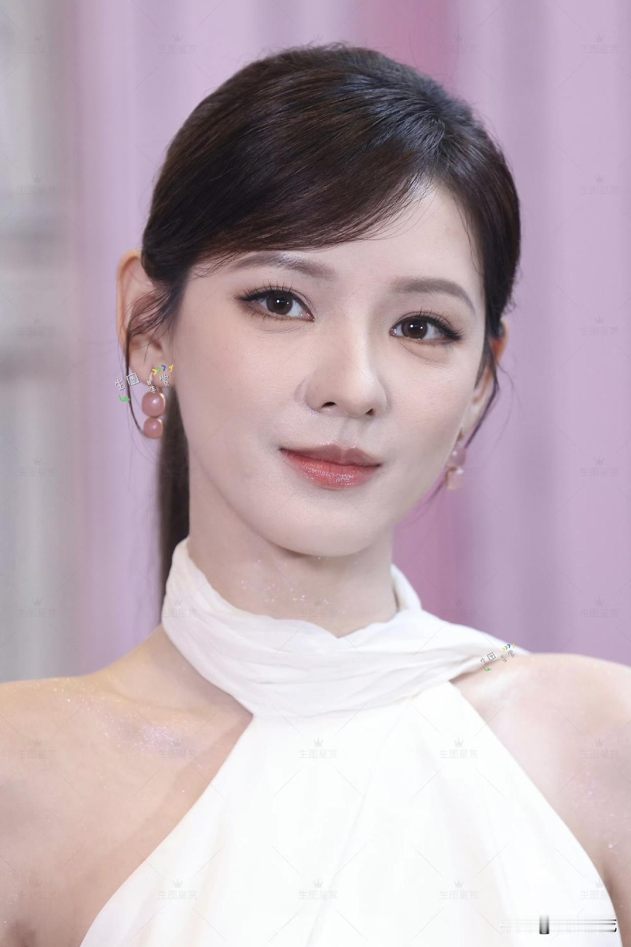 5月27日，张予曦现身上海张园依云200周年快闪活动，一袭奶白色缎面挂脖长裙，直