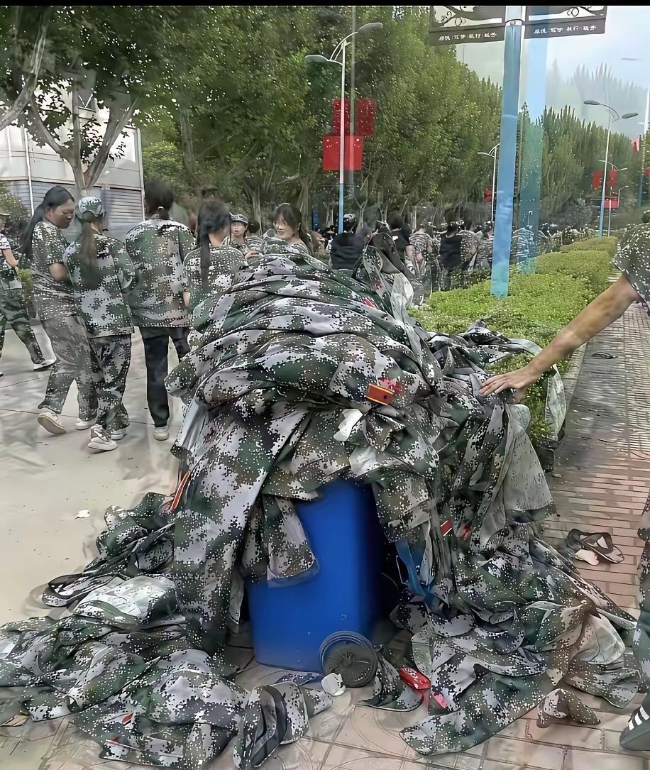 你们丢的不是军训服，是对家国的敬畏！看着一堆迷彩服如弃履般堆在蓝色垃圾桶上