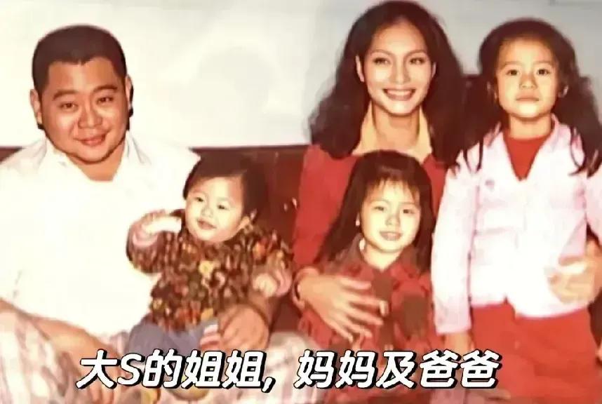 萌娃大S被妈妈搂在怀里，很幸福；妈妈美，爸爸在，一家五口团团圆圆的。大S从小