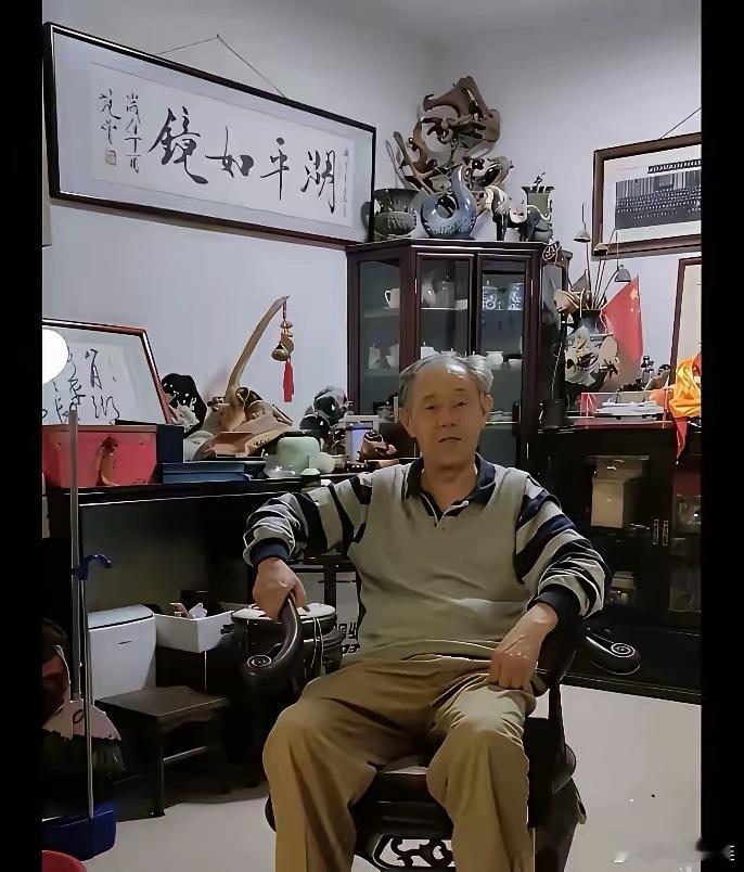 徐湖平这张照片里，最大的亮点不是那张梨花椅，也不是满屋子的古董文物。最大的亮点是