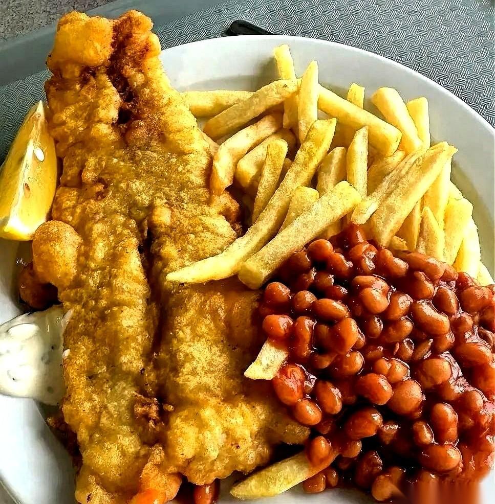 “尝尝正宗英式早餐！”导游笑眯眯地一指。我叉起那根焦黄的猪肉肠，刚凑到嘴边，一股