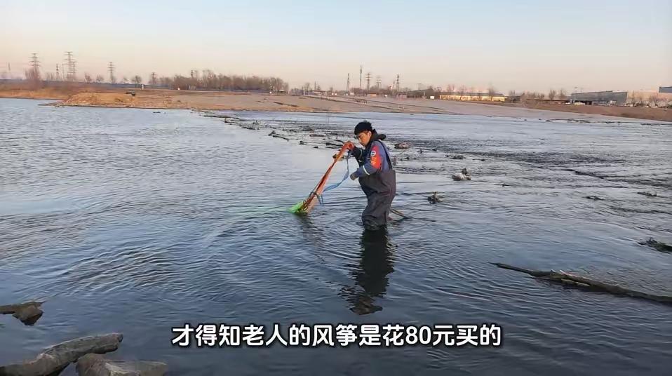 北京一老人在河边放风筝，老人花80块钱买的风筝掉到河里了，老人从河里往回拉风筝，