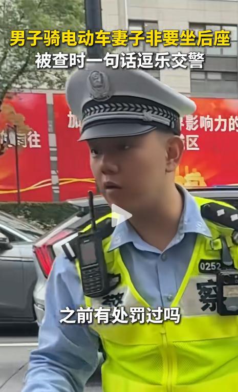 上海一名男子骑电动自行车载着妻子在路上行驶时被交警拦下，原因是违规载人。交警询问