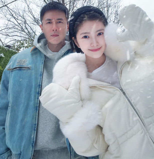 杜淳老婆王灿晒出一组合影照片中的王灿身穿白色羽绒服，白色毛领配上白色毛边手套，