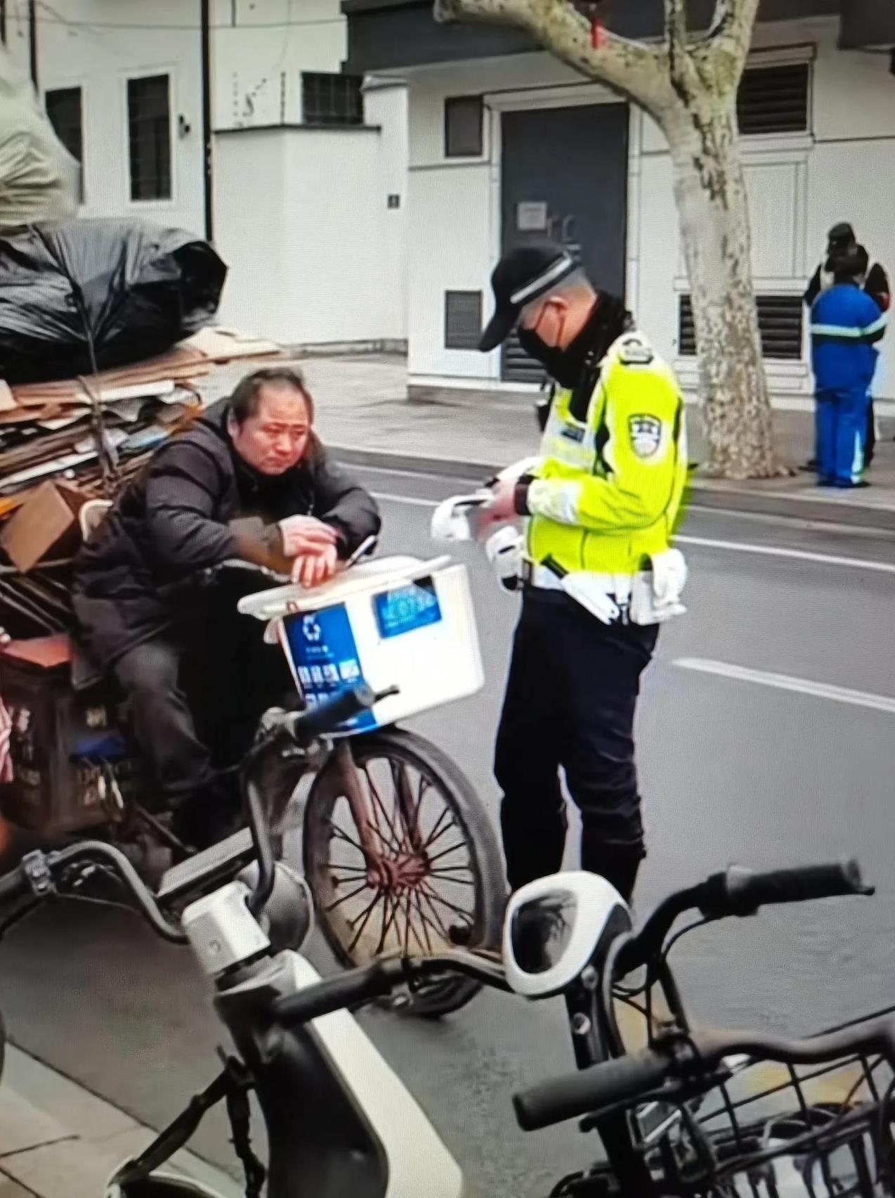 一收废品大哥被一穿制服人员拦下，大哥默默的等着全程没说一句话，接过递过的纸条扔进