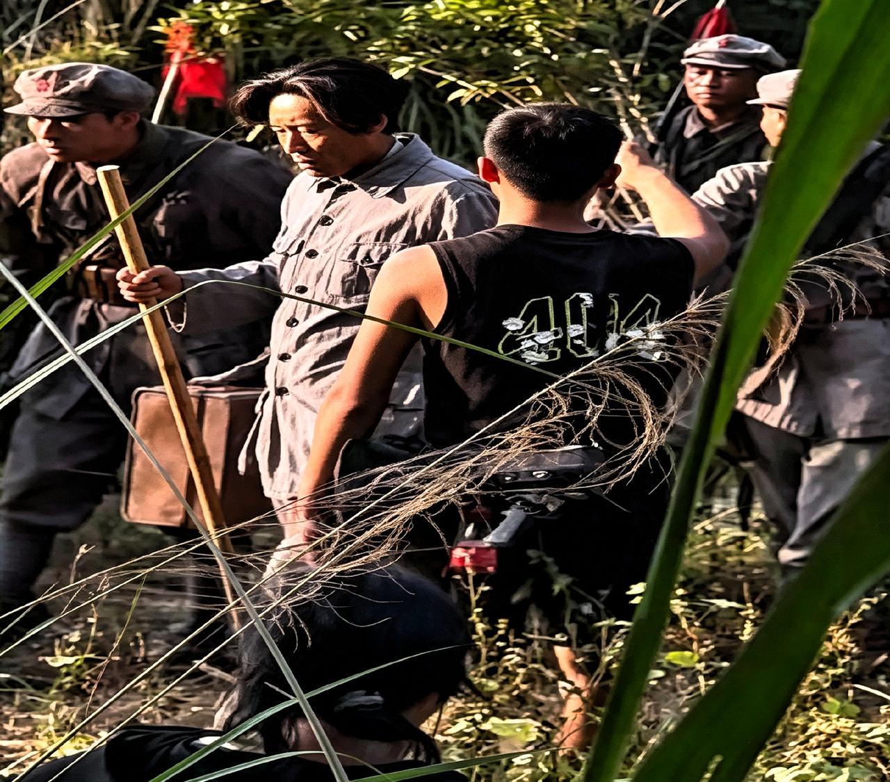 于和伟拍《伟大的长征》被路人抓拍了。他穿灰军装拄着棍子，眼神挺像那么回事。结果后