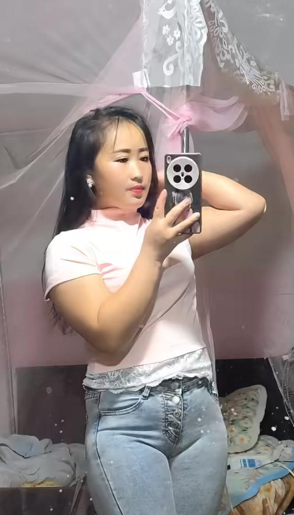 女子在出租屋穿紧身牛仔裤自拍。