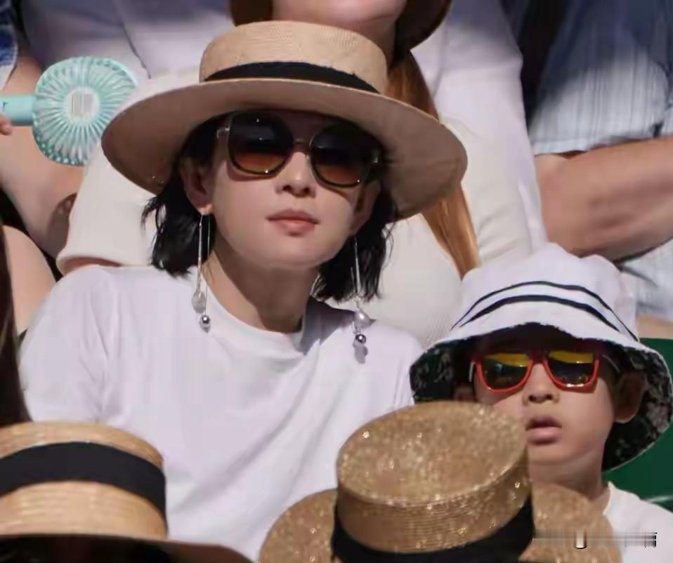 章子怡两个领着孩子去国外看网球了。孩子戴着小墨镜儿，像一个小大人一样。暑假期