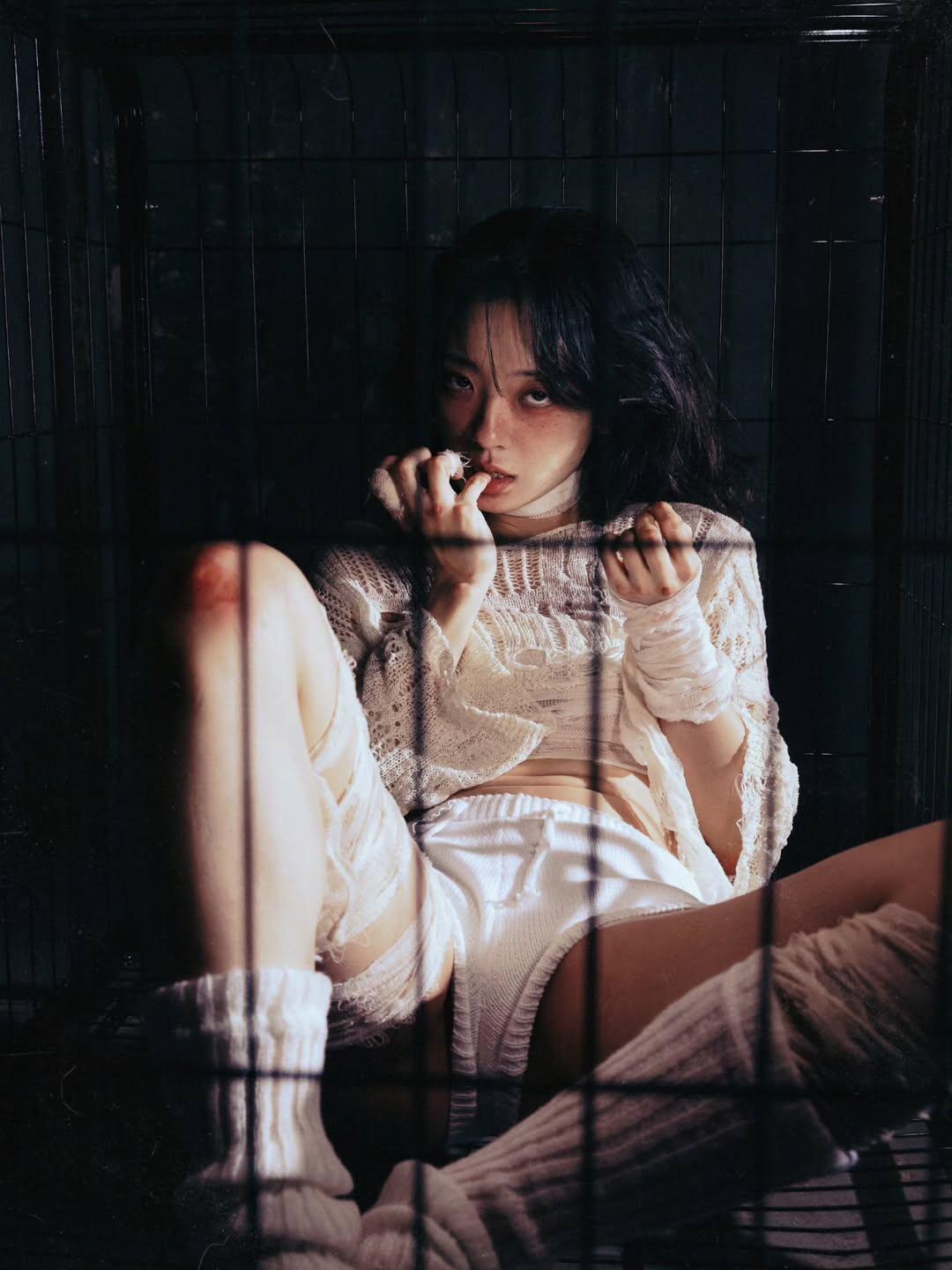 作品有用上帝视角的俯拍，拍出了牢笼主题里少见的孤独感。镜头从高空向下定格，模特蜷