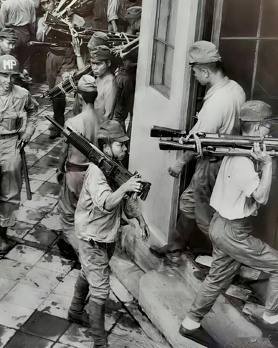 1945年，香港的街巷间，战败的日军正忙乱地收拾武器。潮湿的地砖映出他们佝偻身