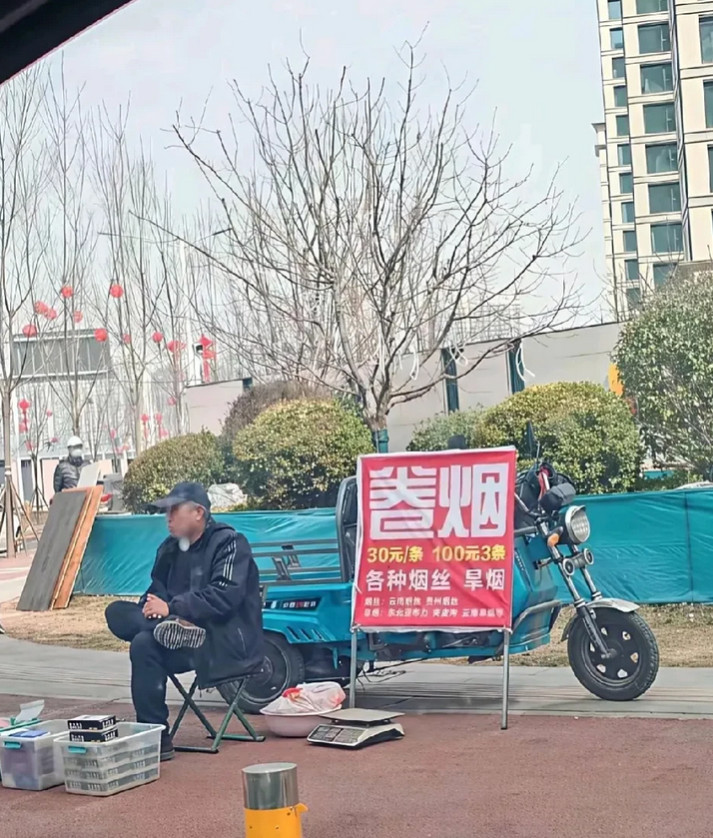 这位大爷居然敢摆摊卖卷烟，这样会不会违法呀？