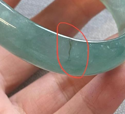 新疆乌鲁木齐，女子在玉器店看中一只价值百万的手镯，店员提醒她不要拿托架，要拿手镯