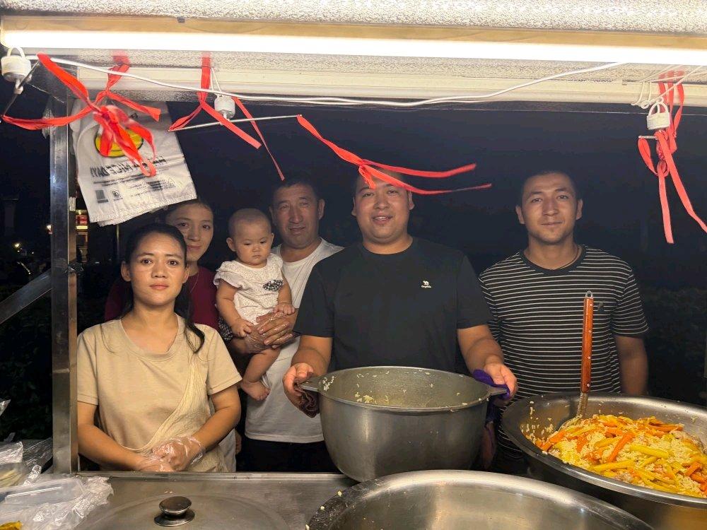 上周在江汉路夜市撞见个狠人，95后小伙推着小推车卖手抓饭，后面跟着爸妈、老婆还有