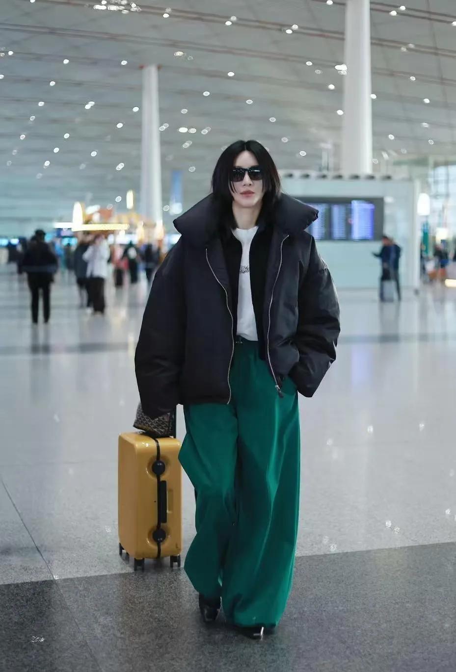 尚雯婕这机场穿搭，是把松弛感焊在身上了✈️黑色宽松羽绒服+祖母绿阔腿裤，简