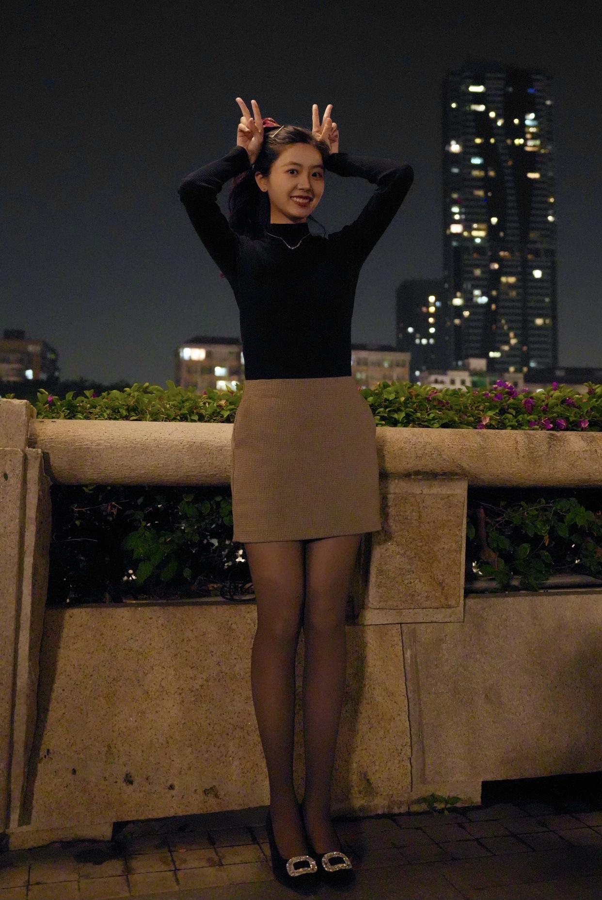 怎样穿搭能显示出温柔的女生气质?夜晚的街角，她微笑着蹲下，仿佛在等待谁的出现。