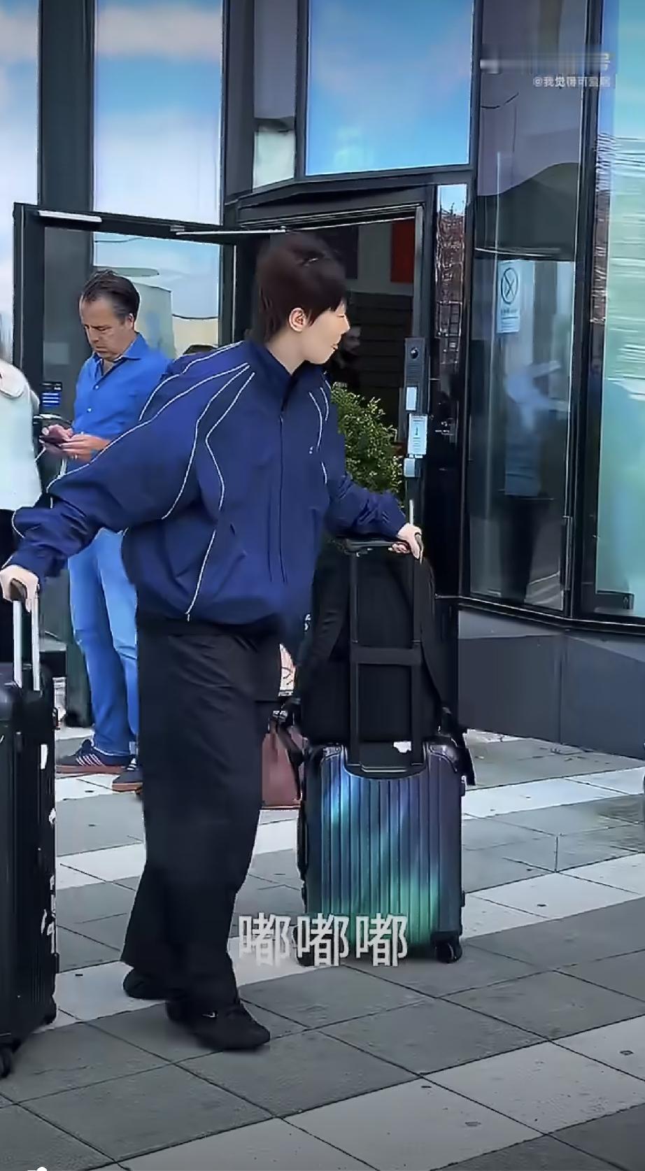 昨晚国乒选手从瑞典启程回京，曼昱身穿蓝色休闲服，推着她的两个行李箱，沉甸甸大行