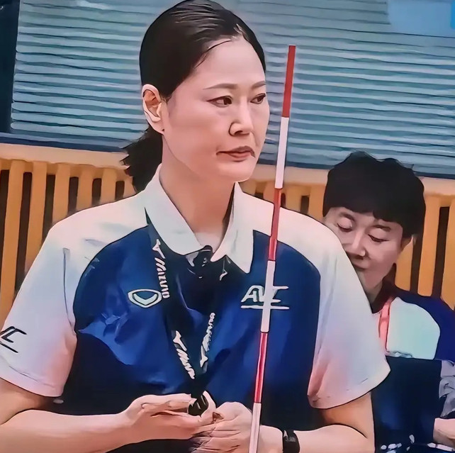 亚运会女排决赛的转播镜头多次对准这位主裁，她穿搭得体，仪态端庄，手执裁判杆，神情严肃专业，一举一动全