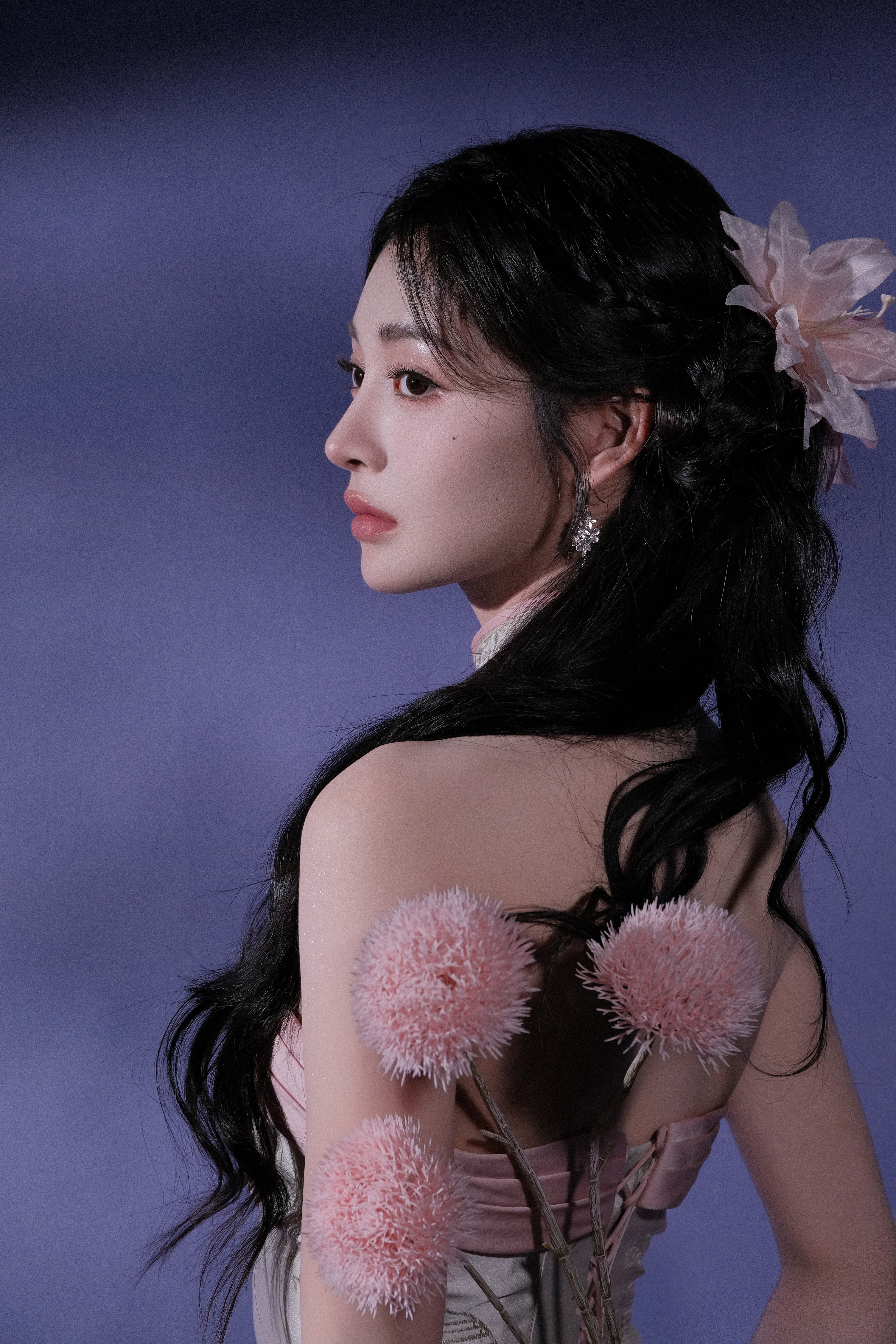 周洁琼一袭粉裙，勾勒柔美曲线，发间花饰点缀，在淡紫氤氲中，如古典画中走出的佳