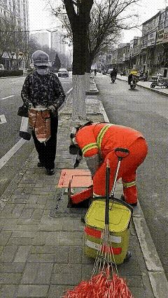 后面的大妈好想捡那个圆盒子，可前面的环卫工人却这样做。走在人行道上，本来挺