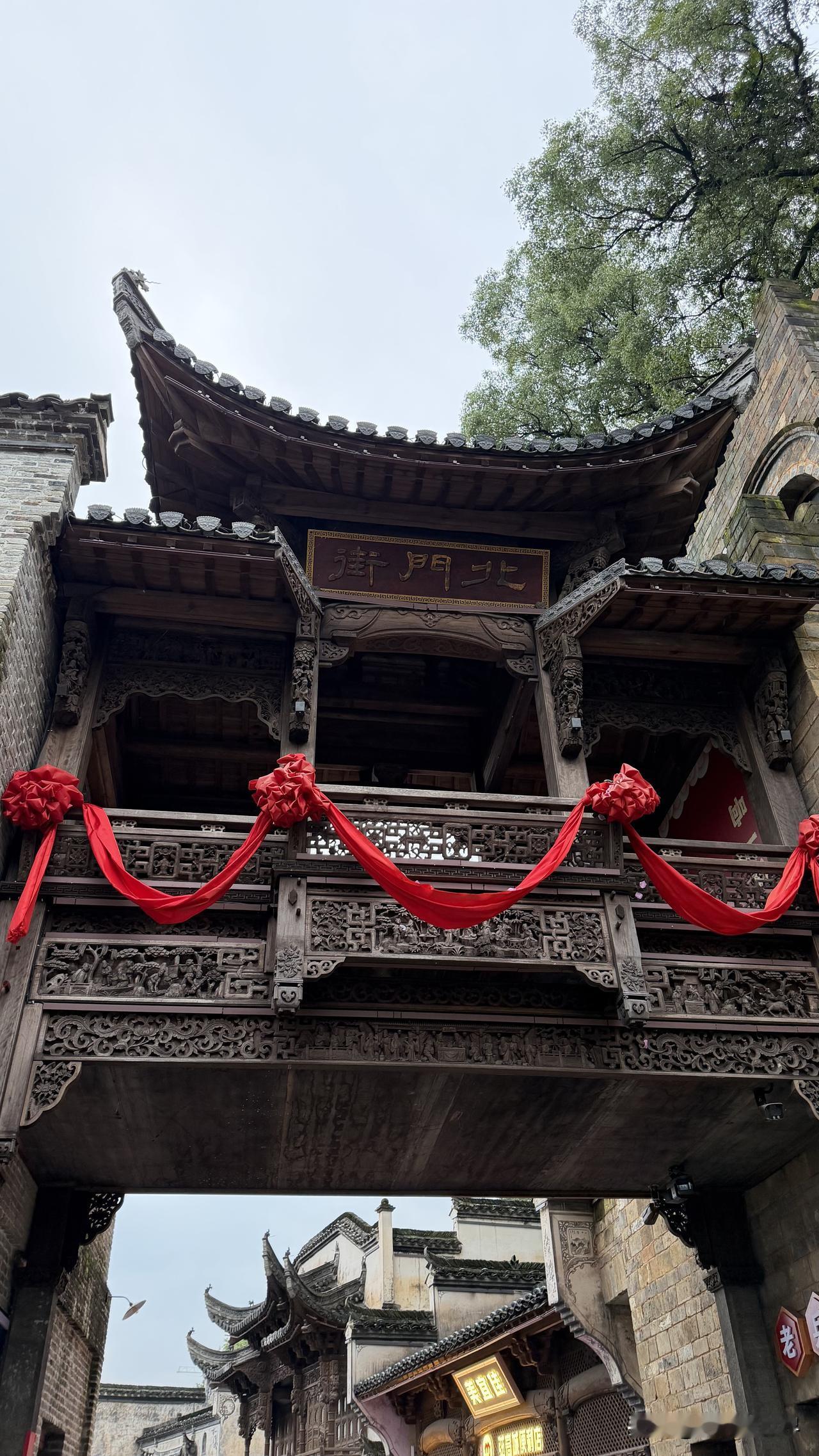 漫步婺源古镇，白墙黛瓦依山临水，马头墙掠过低山薄雾，青石板路淌着潺潺溪声。古巷