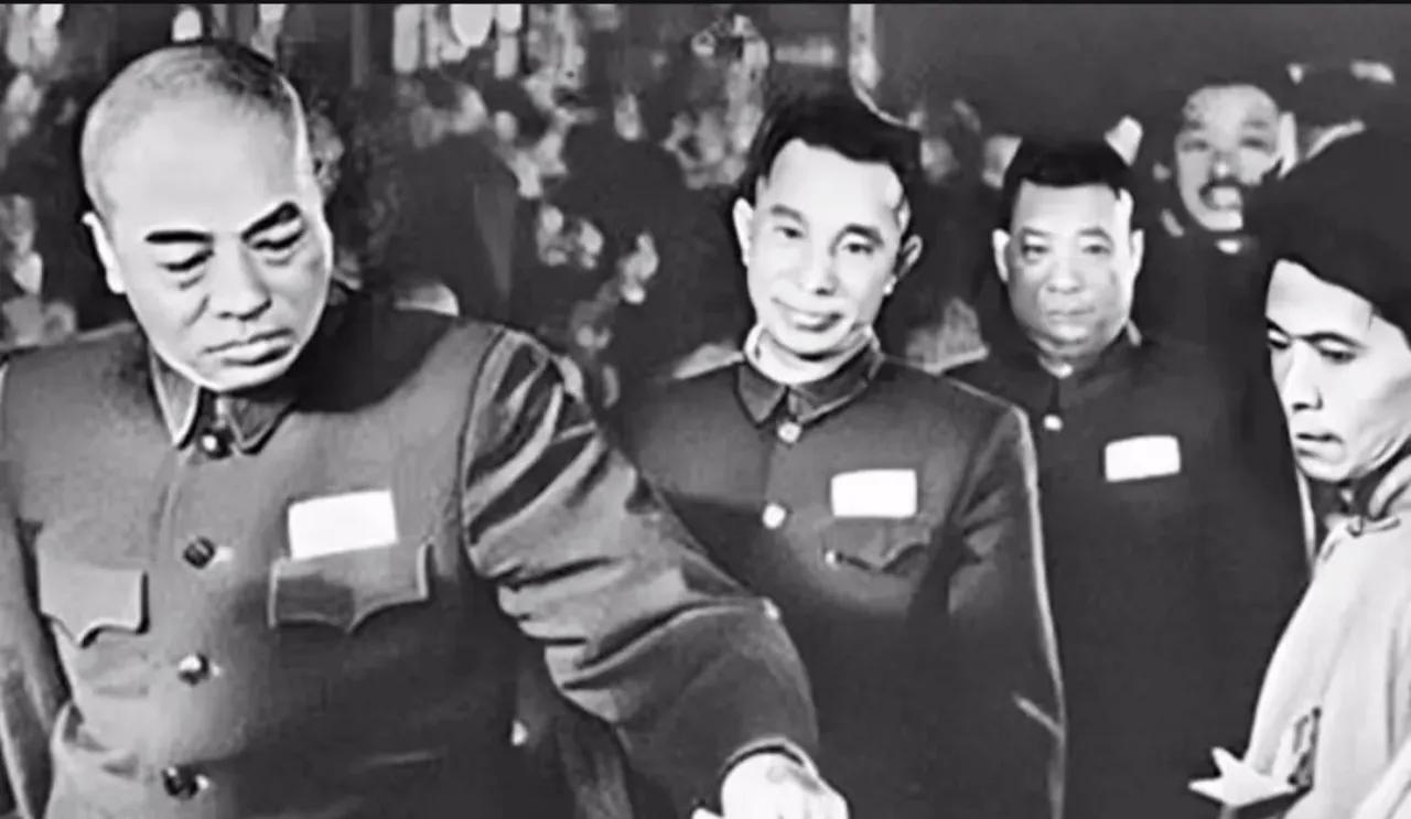 一张老照片，画面中彭老总在工作人员的注视下，正在朝投票箱中投票，彭总后面等待投票