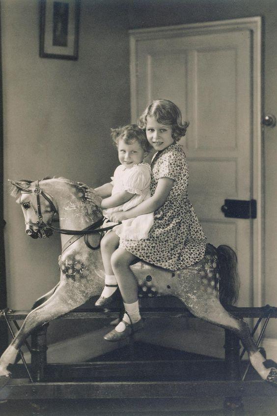 1936年，年幼的伊丽莎白公主和妹妹玛格丽特公主一同在家里骑木马！伊丽莎白女王