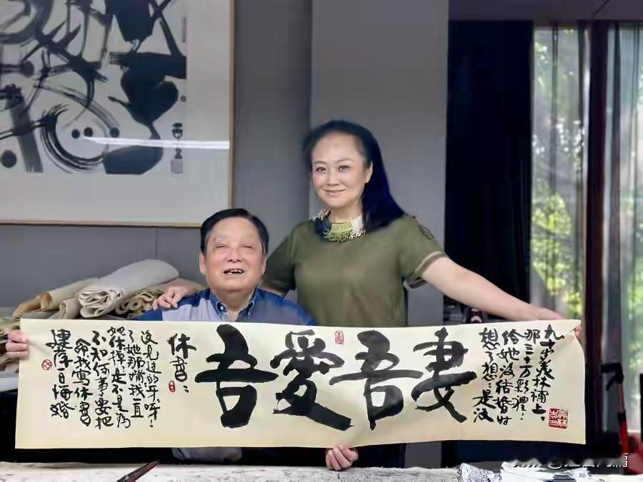 艺术大师韩美林，身旁是他的妻子第四任妻子周建萍。这幅书法作品大字写着吾爱吾妻