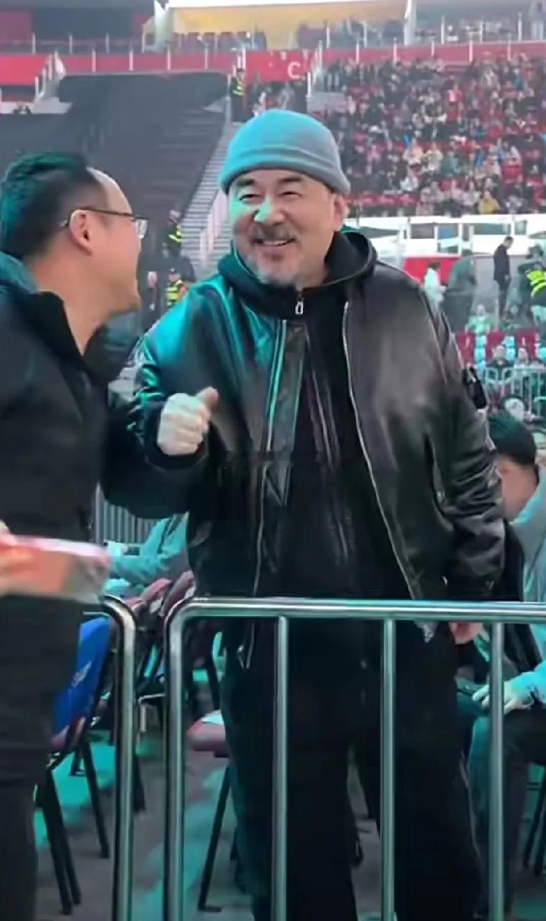 看谭晶演唱会时偶遇陈建斌，他这状态也太好了吧！头戴锅盖毛线帽，黑色皮衣夹克配休闲