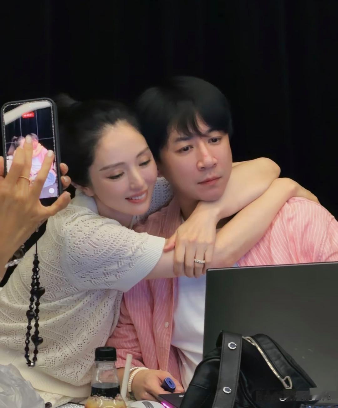 47岁董璇去给老公张维伊的舞台剧捧场，两口子在后台一起合影。她搂着老公脖子，看着