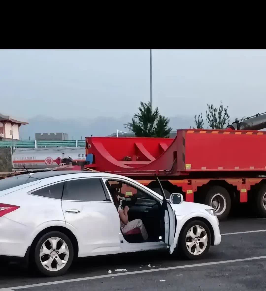在京新高速新疆阜康服务区停车场，发生了一件令人气愤的事。一年轻女性在自己爱车旁边