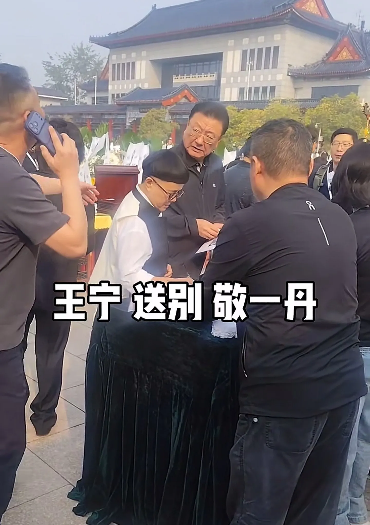 敬一丹告别仪式举行，现场画面曝光！追悼会整体布置低调简约，全程以肃穆送别为核心。灵堂外整齐摆放着各界