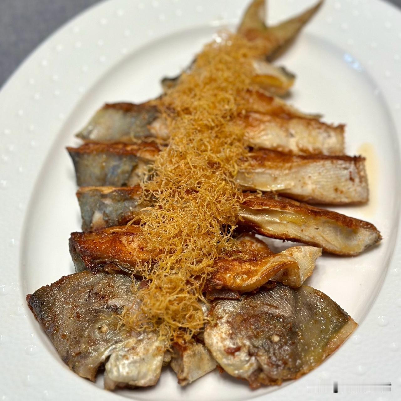 煎得金黄的鱼身上，铺着蓬松的糖丝，甜香裹着鱼肉的鲜，咬开是酥软的暖；砂锅里的肠