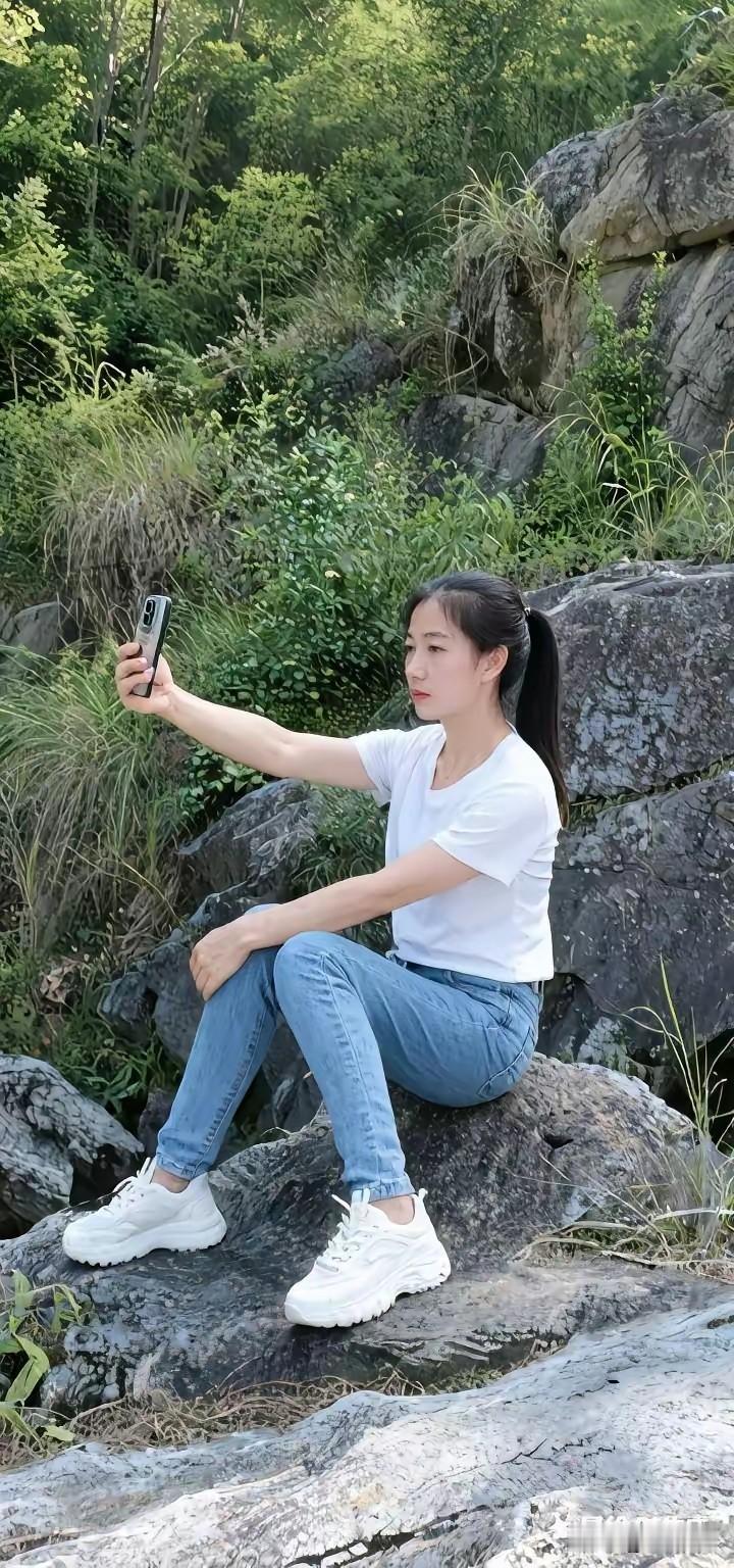 在山间岩石上自拍，享受自然风光