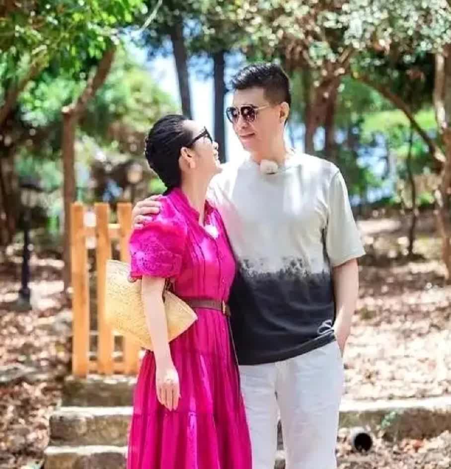 被秦海璐夫妇的甜蜜旅行照甜到啦💕海边露台，她一袭玫红长裙明艳动人，与丈夫依偎