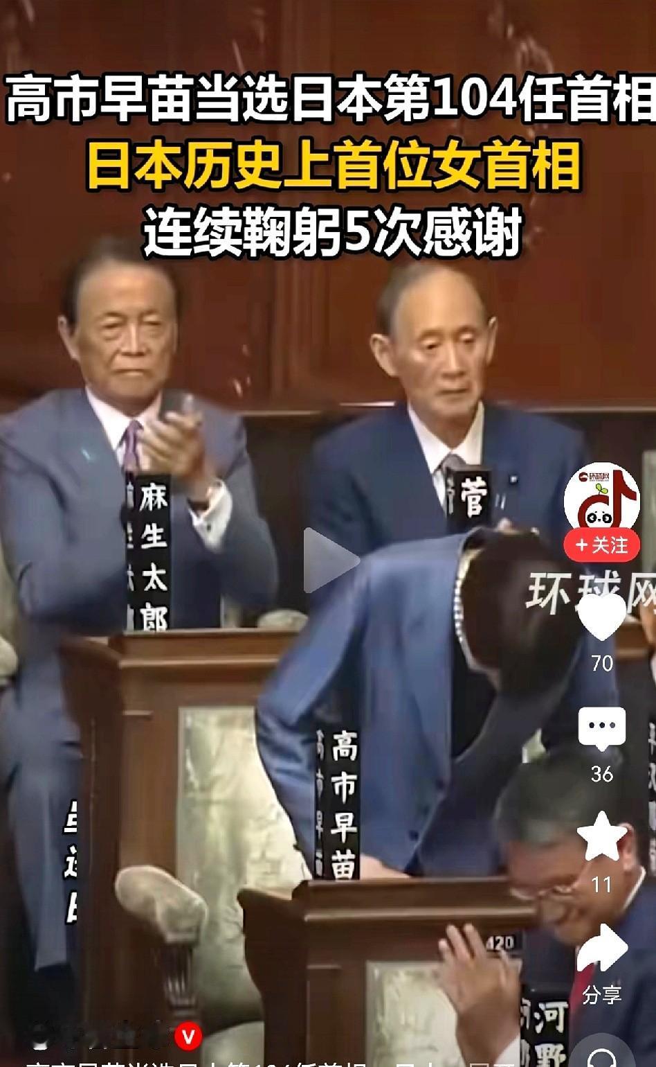 高市早苗？呵，鞠躬鞠得头都快杵地了，腰弯成一张弓。背后那俩男的，脸跟水泥板似的鼓