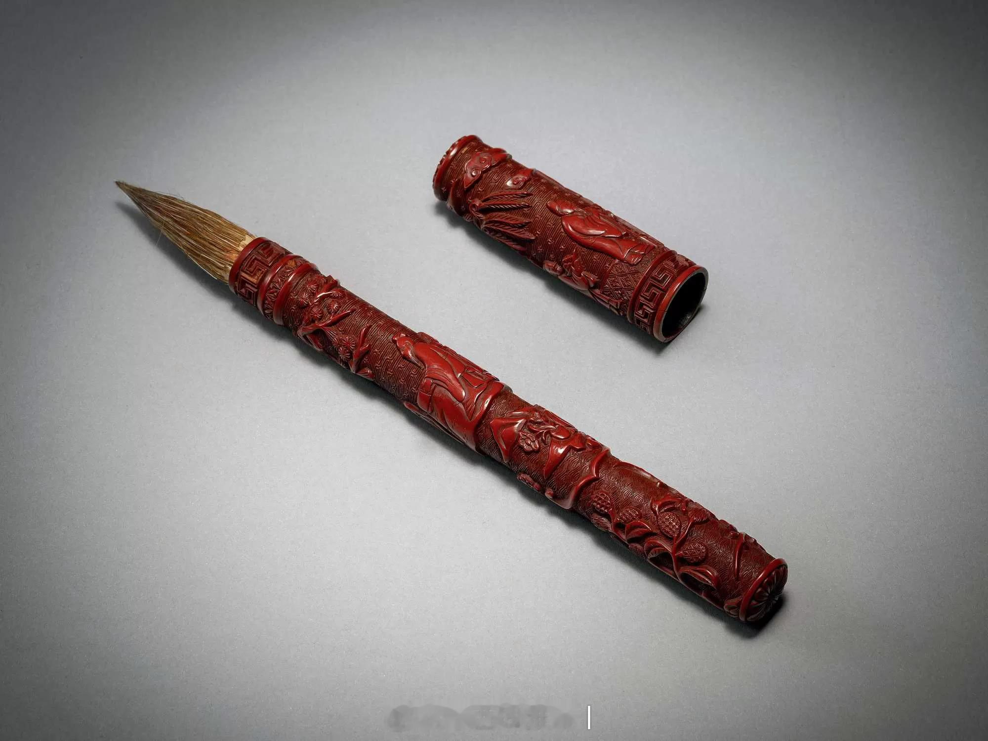 髹饰录|明剔红山水人物图毛笔此笔作束节式，通体髹朱漆，分管身和笔帽两部分。
