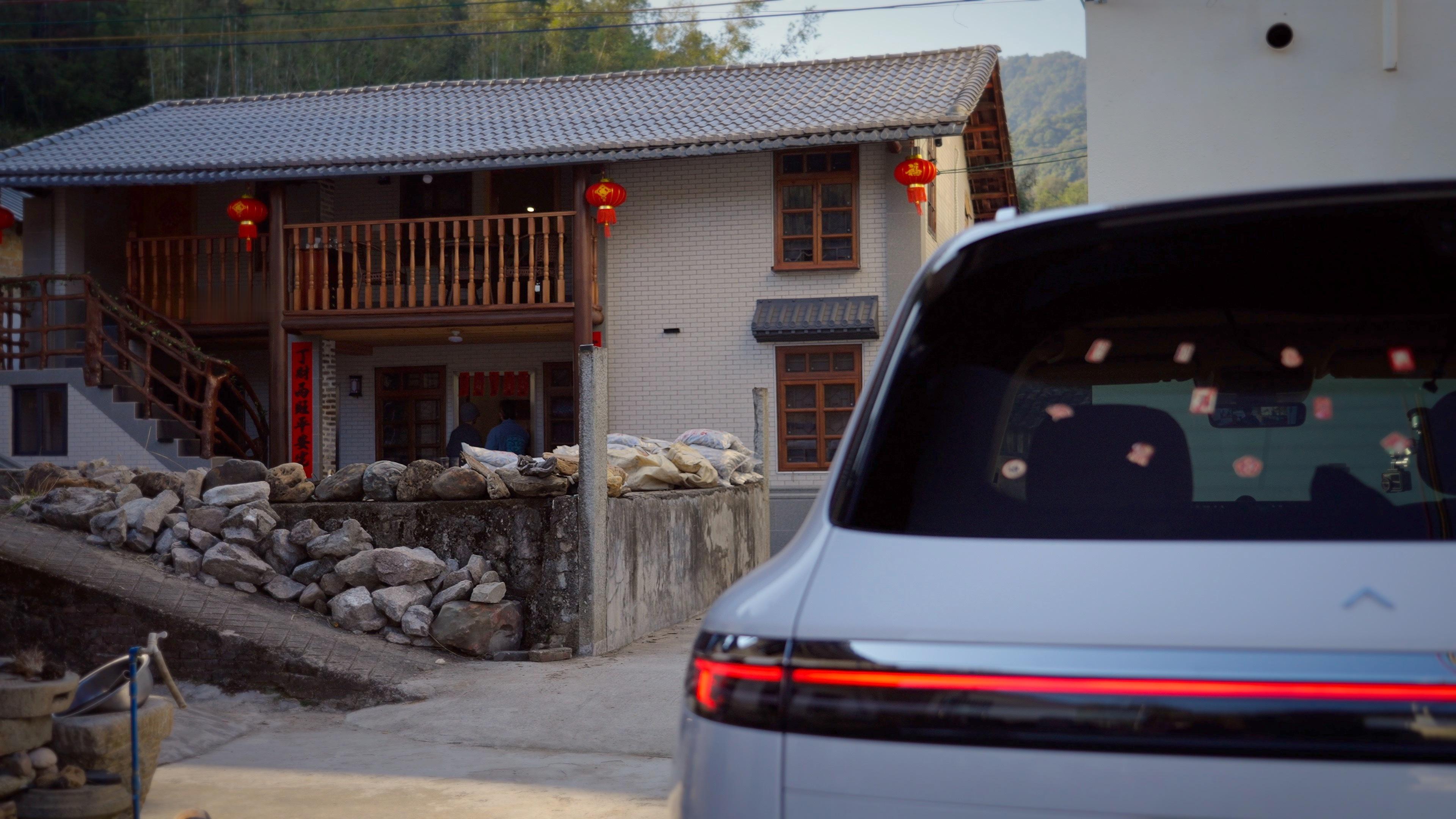 问界M7无论停在都市楼宇下，还是故乡的门前，它沉稳流畅的线条总能安静地融入背景。