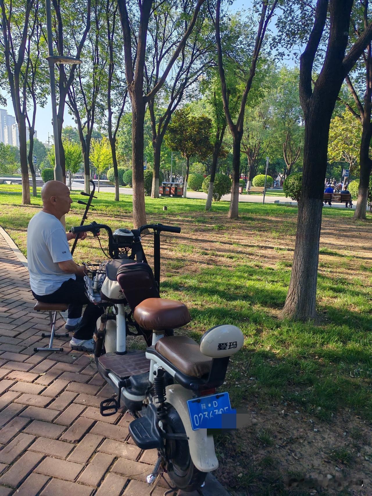 两种生活，两种晚年这是我近日拍到的几张图，公园内一个大叔坐在小马扎上，悠然自得