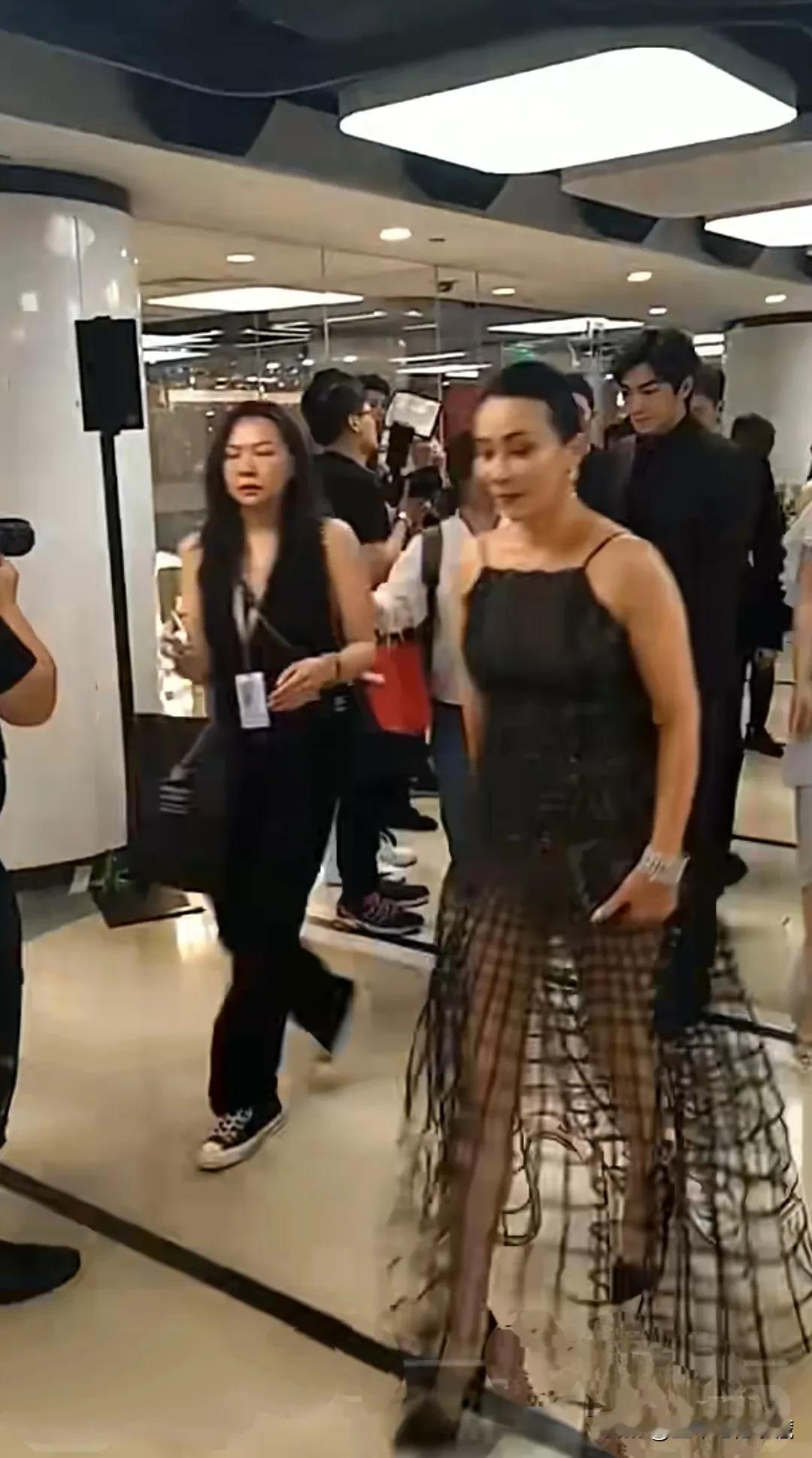 著名演员刘嘉玲一身黑色吊带渔网裙出席活动，已经54岁的刘嘉玲太敢穿了，这身渔网裙