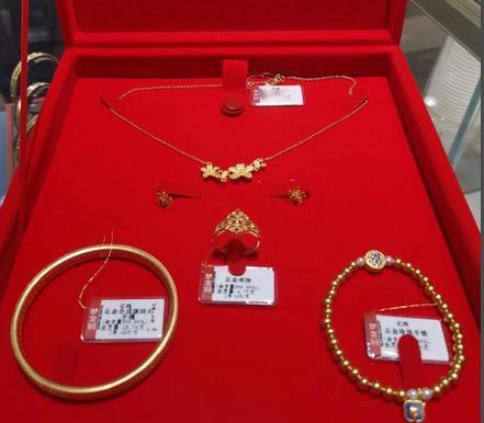 一个男孩站在柜台前算了很久，最后还是放下了那只克重大的龙凤镯，转头选了一条细小的