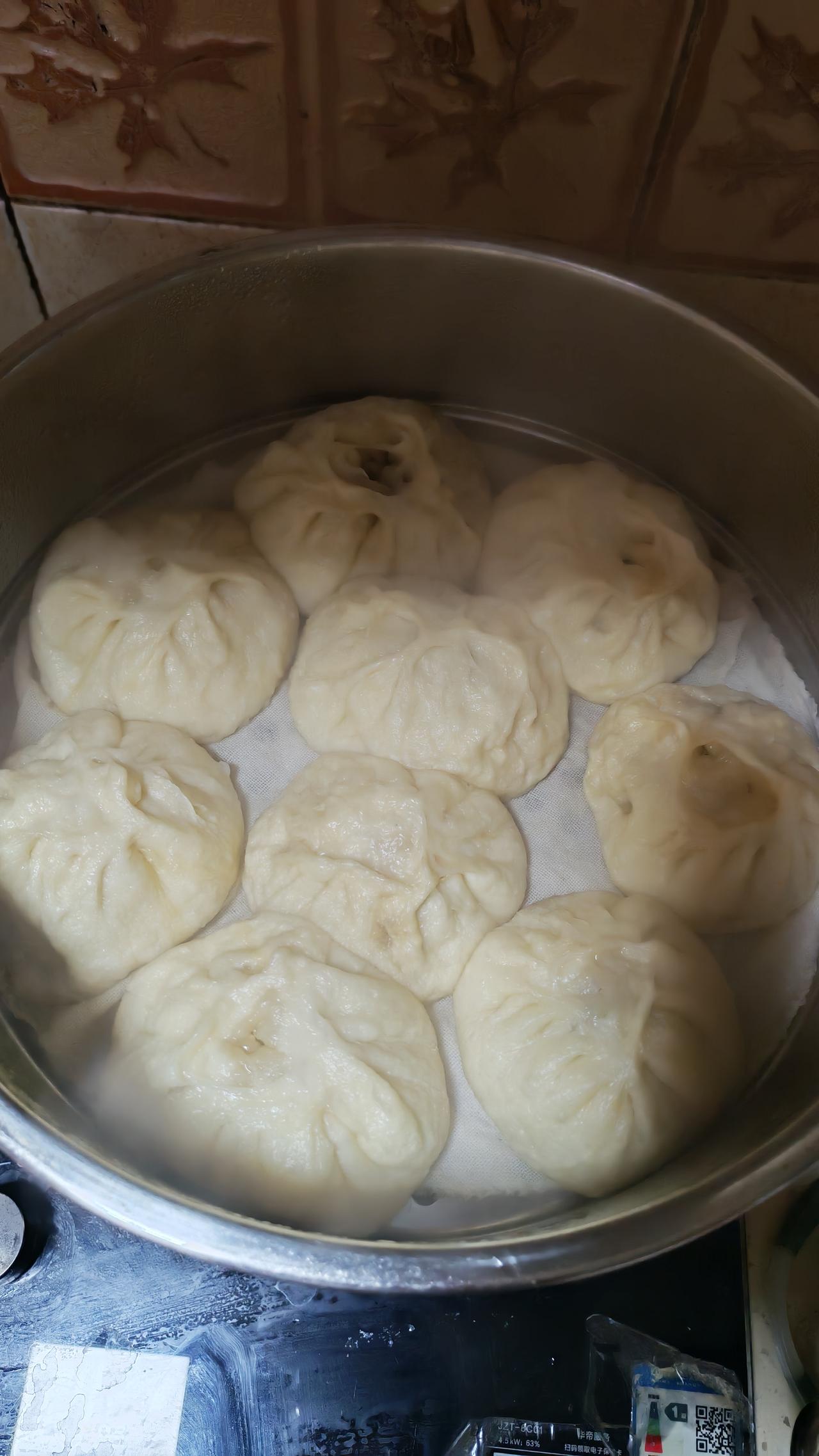 蒸笼一掀，热气裹着麦香直冲鼻腔，白胖胖的包子个个圆滚滚像小胖墩，捏起来暄软回弹，