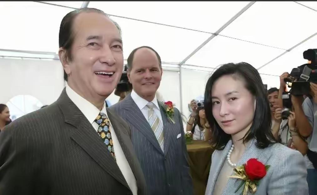 90年代末，何鸿燊带着接班人何超琼出席活动时的照片，何超琼身着灰色套装立于父亲身