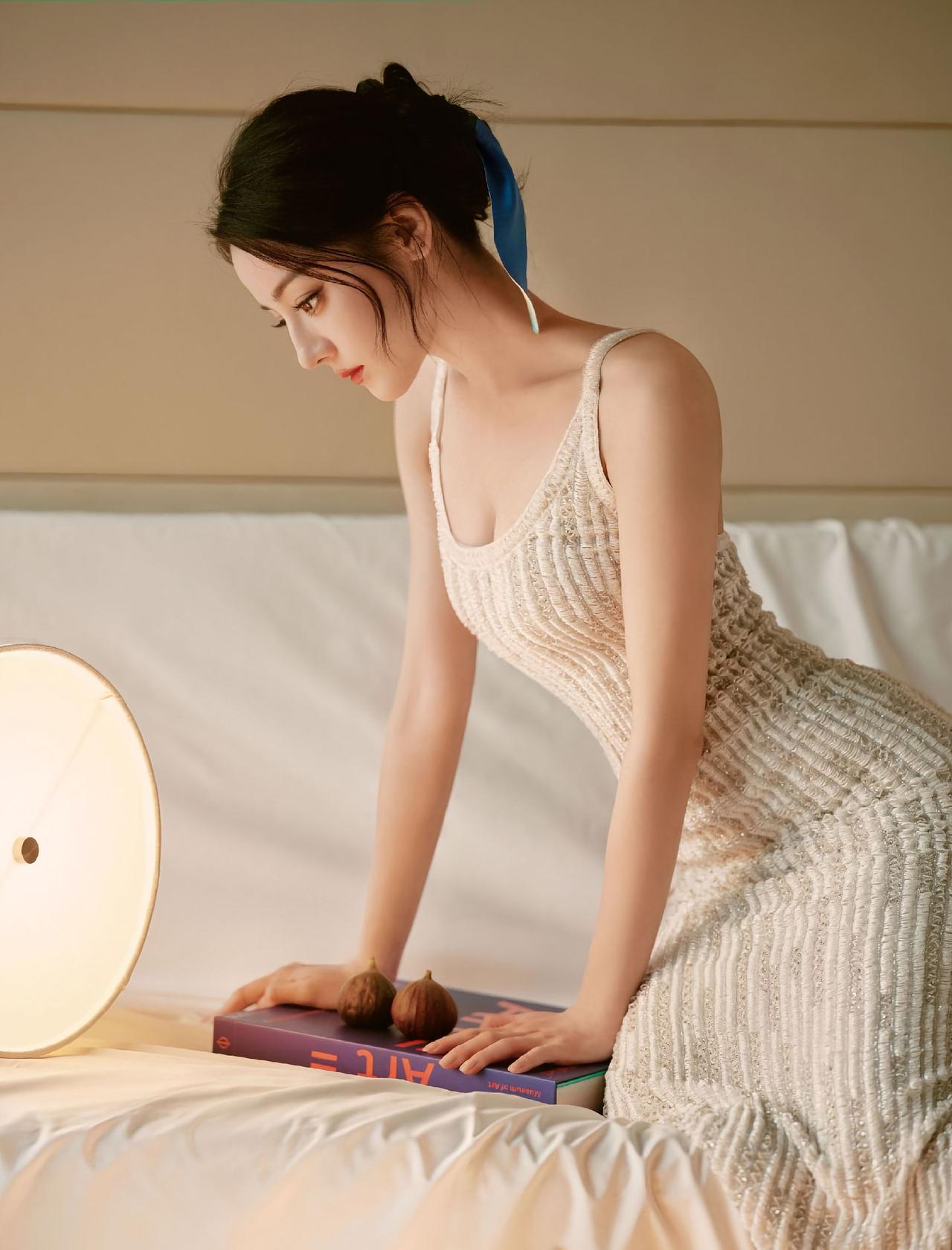 热巴灯影里的私语暖光漫过床沿把白裙的褶皱，揉成流动的星河蓝丝带系住半