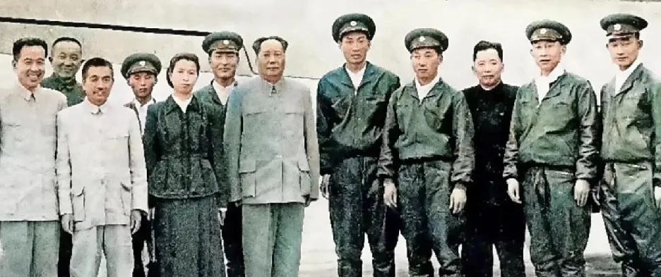 在这张珍贵的历史照片中，伟人身着中山装，身姿挺拔，目光深邃而坚定。身旁夫人着装朴