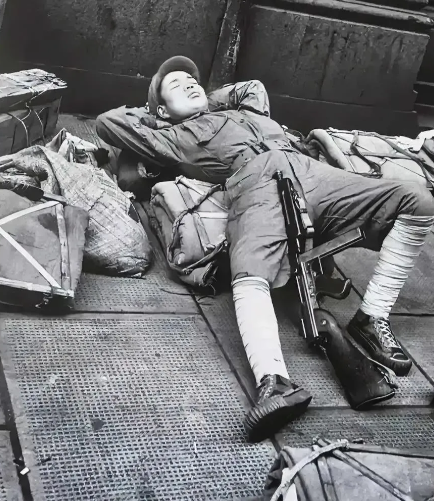 1949年，上海，镜头一名即将撤往台湾的士兵躺在地上休息，看起来很疲惫，也很失落